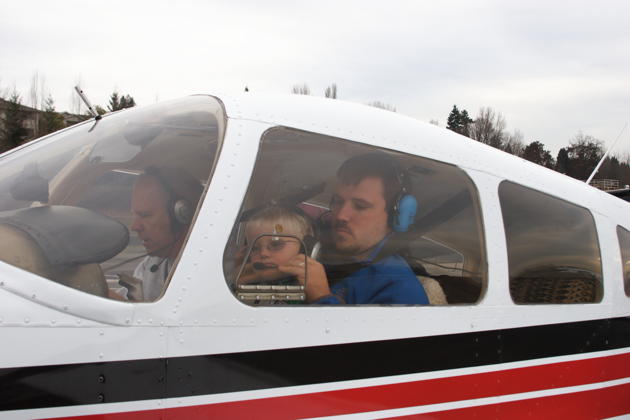 David adjusting Alex's headset in the Warrior for his first flight. Photo by Mary Kasprzyk.