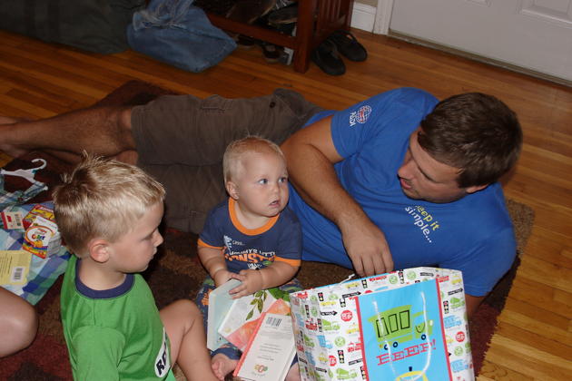Nathaniel opening first Birthday presents with Alex and Dad.