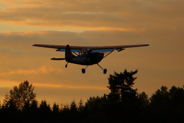 The O-1 Bird Dog departing Evergreen Sky Ranch airport at sunset.