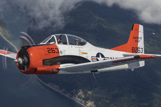 Alyssa 'Smiley' McColly banking with Jim Ostrich's T-34 over Puget Sound waterways, with Mt. Rainier in the distance.