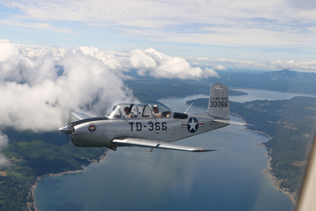 Alyssa 'Smiley' McColly with Jim Ostrich's T-34 over the Hood Canal.