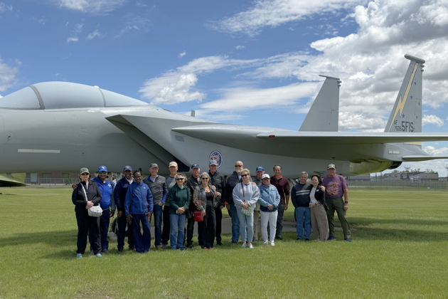 The reunion team in front of the Dakota Territory Air Museum's F-15 in 5th Fighter colors. From left to right: Linda Smith, Ken 'Homer' Smith, Daryl 'Bones' Jones, Martha Jones, Mike 'Levi' Levitt, Stan 'Sundance' Kasprzyk, Mary Kasprzyk, Jim 'Hacksaw' McComas, Lea McComas, Mike 'Pork' VanLaan, Dave 'Over' Szeles, Becky Szeles, Sean 'Sleepy' O'Brien, Coleen O’Brien, Tom 'Konscan' Konicke, Phil 'Lebeau' Nicholson, Dori Nicholson and Ralph 'Root' Moser. The 11 pilots in the photo have over 20,000 combined flight hours in the F-15 Eagle. Alison Levitt also attended the reunion, but was visiting her Mom locally during the F-15 photo shoot.